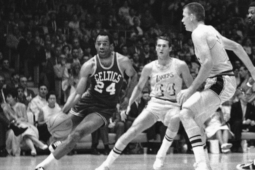 FILE - Boston's Sam Jones, left, drives past the Lakers' Jerry West (44) and drives along the baseline towards the basket.