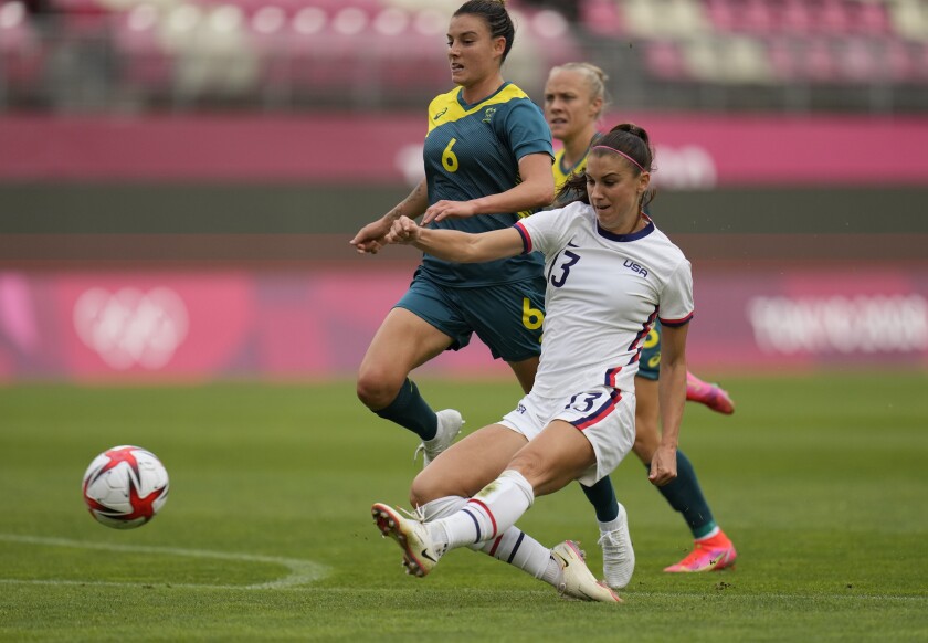Alex Morgan, right, kicks the ball during a women's soccer match against Australia