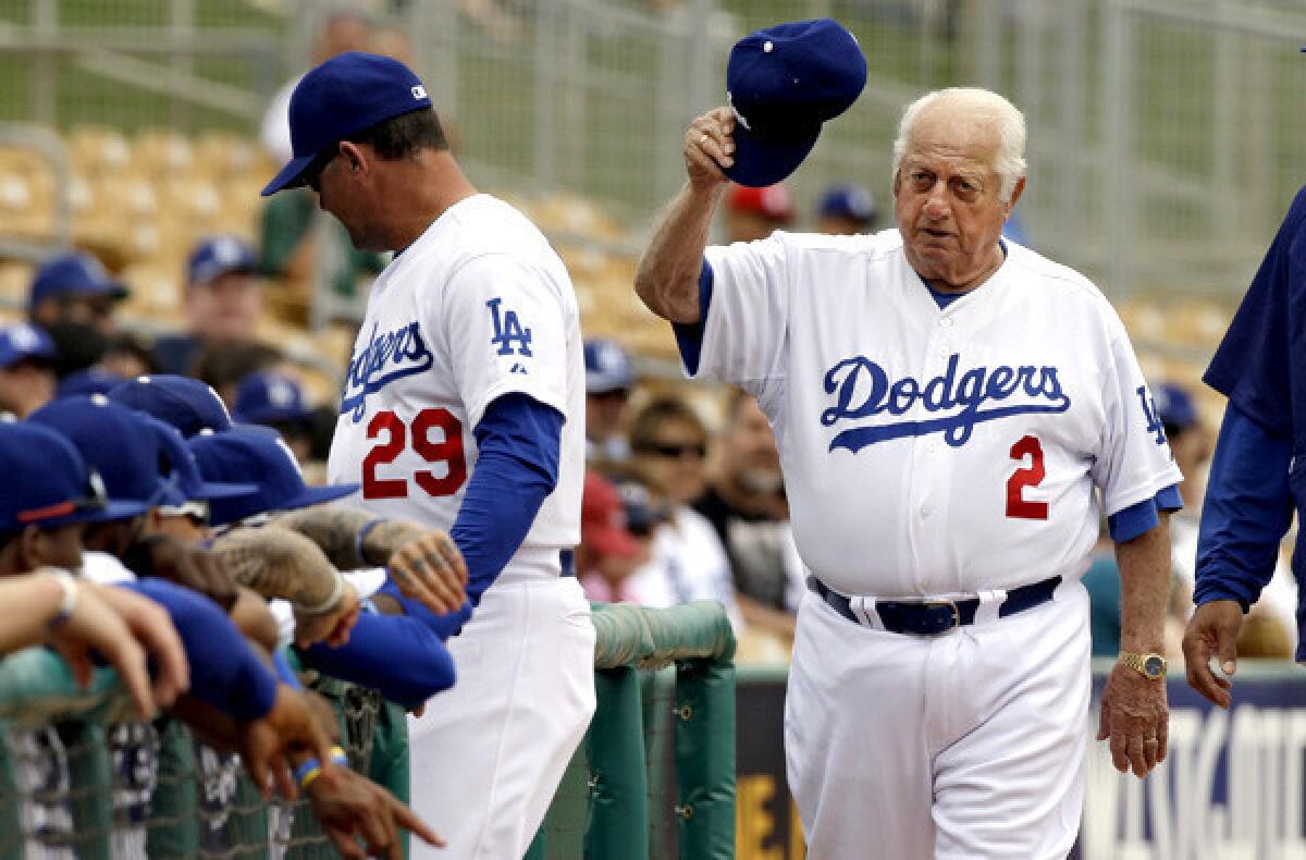Former Dodgers manager Tom Lasorda acknowledges the crowd as he heads to the dugout before an exhibition game last spring in Glendale, Ariz.