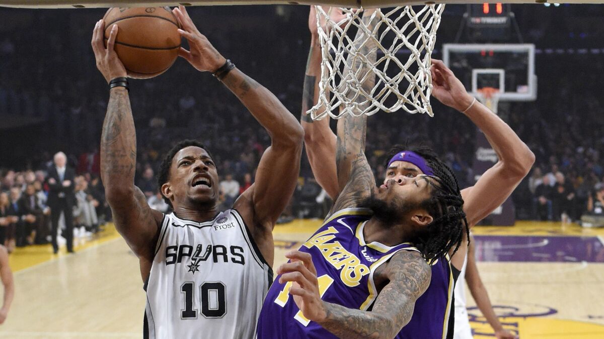 Lakers forward Brandon Ingram tries to block a shot by Spurs guard DeMar DeRozan during the first half Wednesday night.