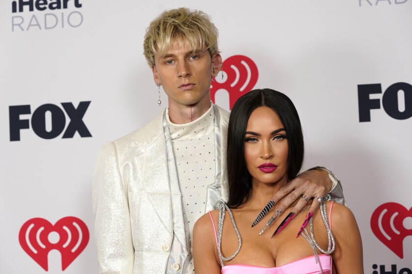 FILE - Megan Fox, right, and Machine Gun Kelly attend the iHeartRadio Music Awards on May 27, 2021, in Los Angeles. Fox and Kelly are engaged. The actor and rapper have decided to legalize their dramatically eccentric coupling, according to Instagram videos that each posted Wednesday, Jan. 12, 2022. (AP Photo/Chris Pizzello, File)
