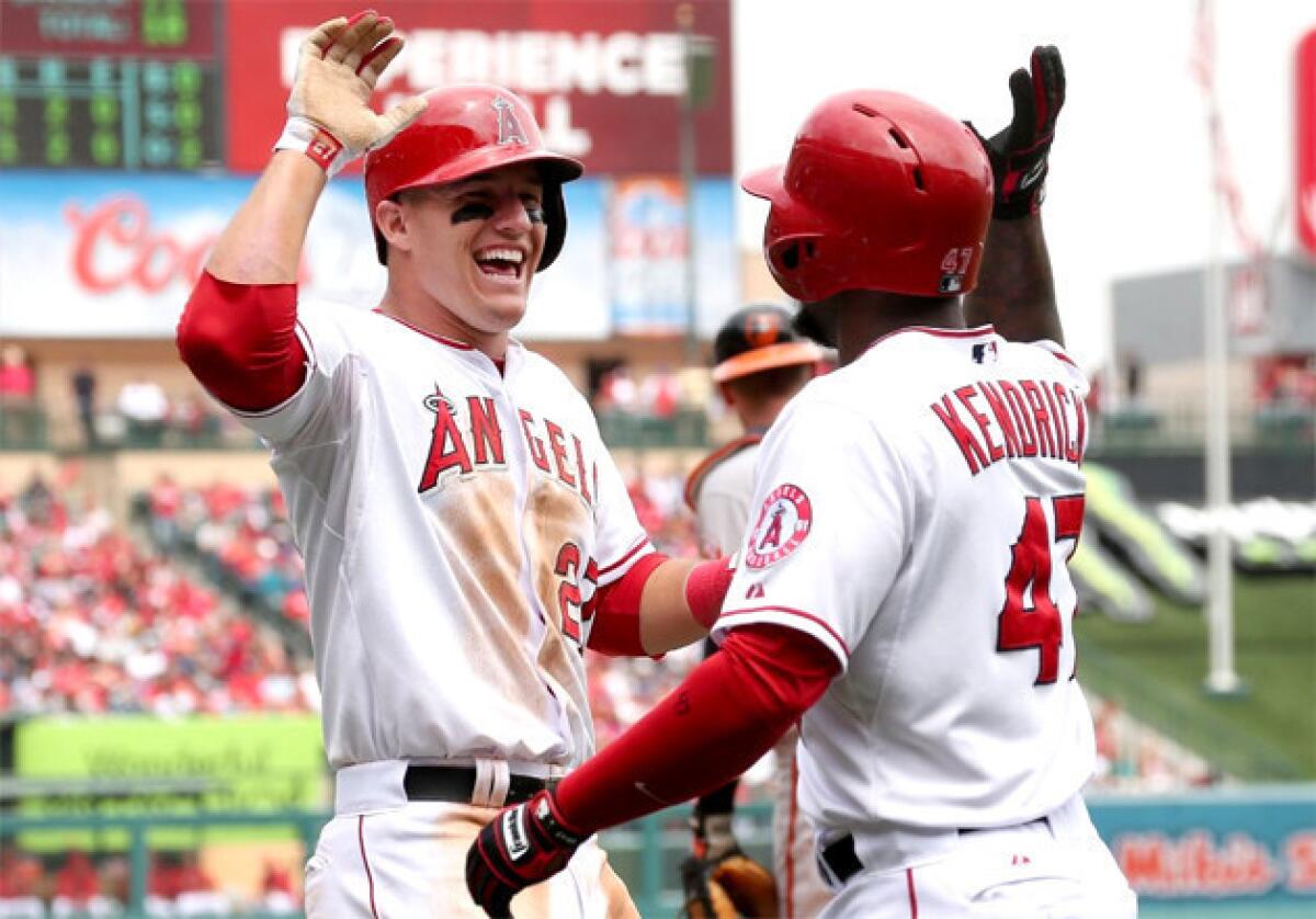 Angels' Mike Trout celebrates with Howie Kendrick after scoring a run against the Baltimore Orioles.