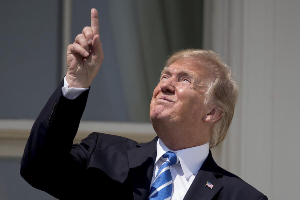 El presidente estadounidense Donald Trump, sin protección, apunta al Sol durante el eclipse solar, desde la Casa Blanca.