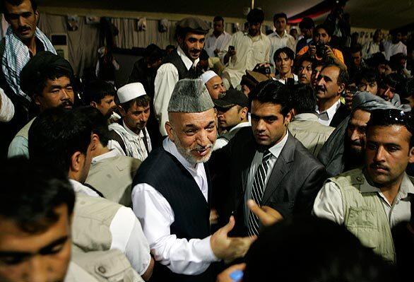 President Hamid Karzai center, greet his supporters during an election rally in Kabul, Afghanistan on Friday. During his first campaign rally in the capital, Afghanistan's president shook hands and roused supporters with promises to hold international troops more accountable.