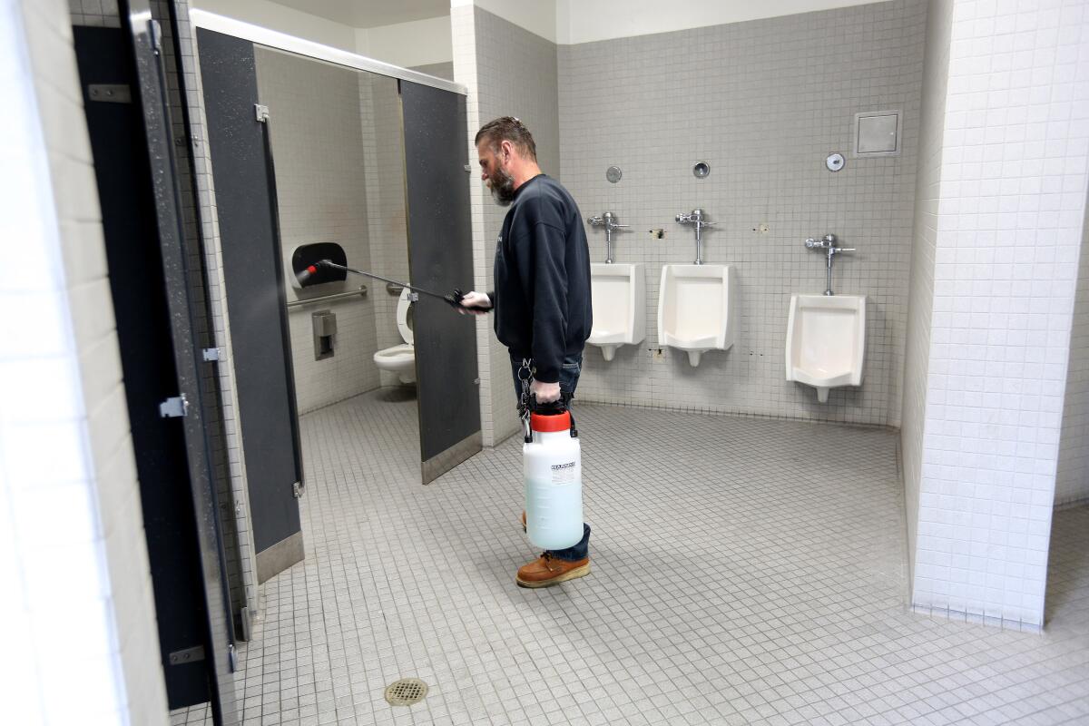 Carlos Martinez disinfects bathrooms while students are not on campus at La Cañada High School.