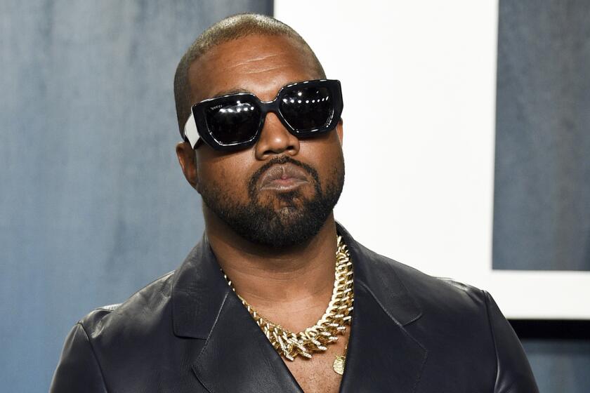 Kanye West wearing sunglasses and a gold necklace