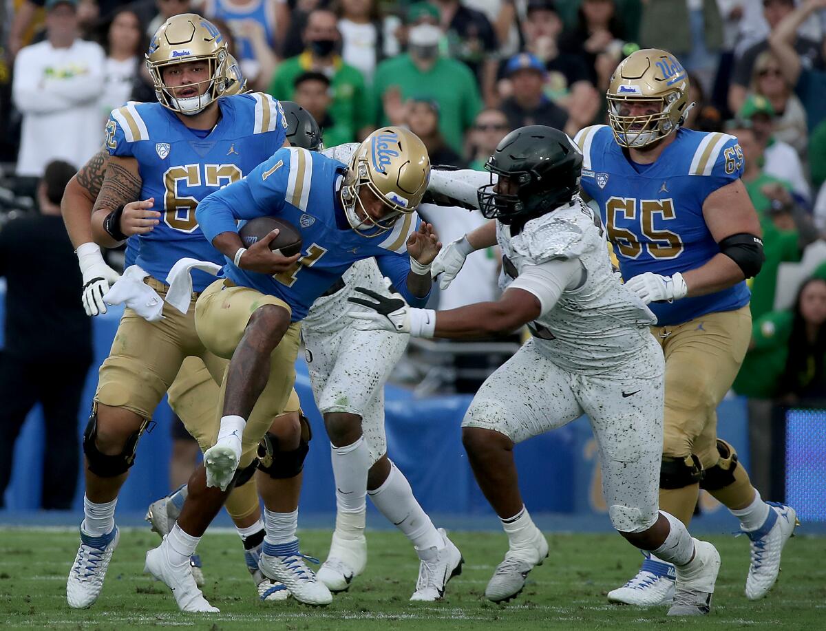 UCLA quarterback Dorian Thompson-Robinson is brought down for a loss by Oregon defensive end Brandon Dorius