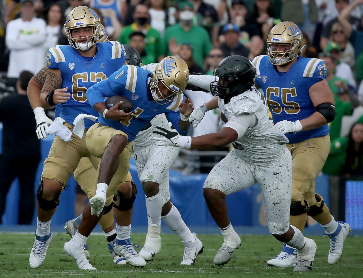 UCLA quarterback Dorian Thompson-Robinson is brought down for a loss by Oregon defensive end Brandon Dorius 