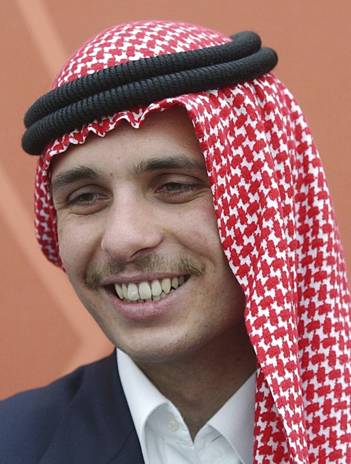 FILE - Jordan's Crown Prince Hamzah smiles during a royal lunch hosted for tribesmen at the Royal Palace compound in Amman, Jordan in this May 26, 2004, file photo. The royal court in Jordan said Tuesday, March 8, 2022, that the half-brother of King Abdullah II has apologized for his role in a rare palace feud last year and is seeking the king's forgiveness. Prince Hamzah was accused of involvement in a plot to destabilize the Western-allied kingdom and was placed under house arrest last April. (AP Photo/Hussein Malla, File)