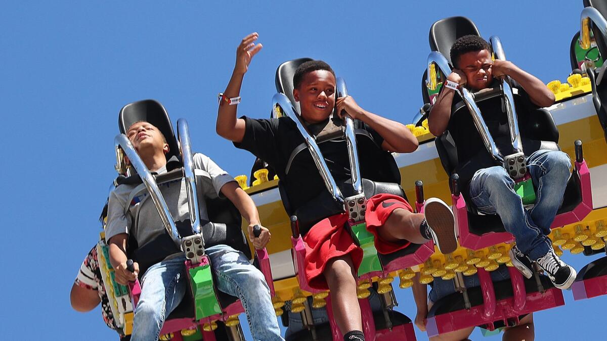 Kids have mixed reactions as they are sent upside down and sideways several times on the Tango ride on the first day of the Los Angeles County Fair on Aug. 31. Entrance prices won't increase this year, an effort to boost attendance.