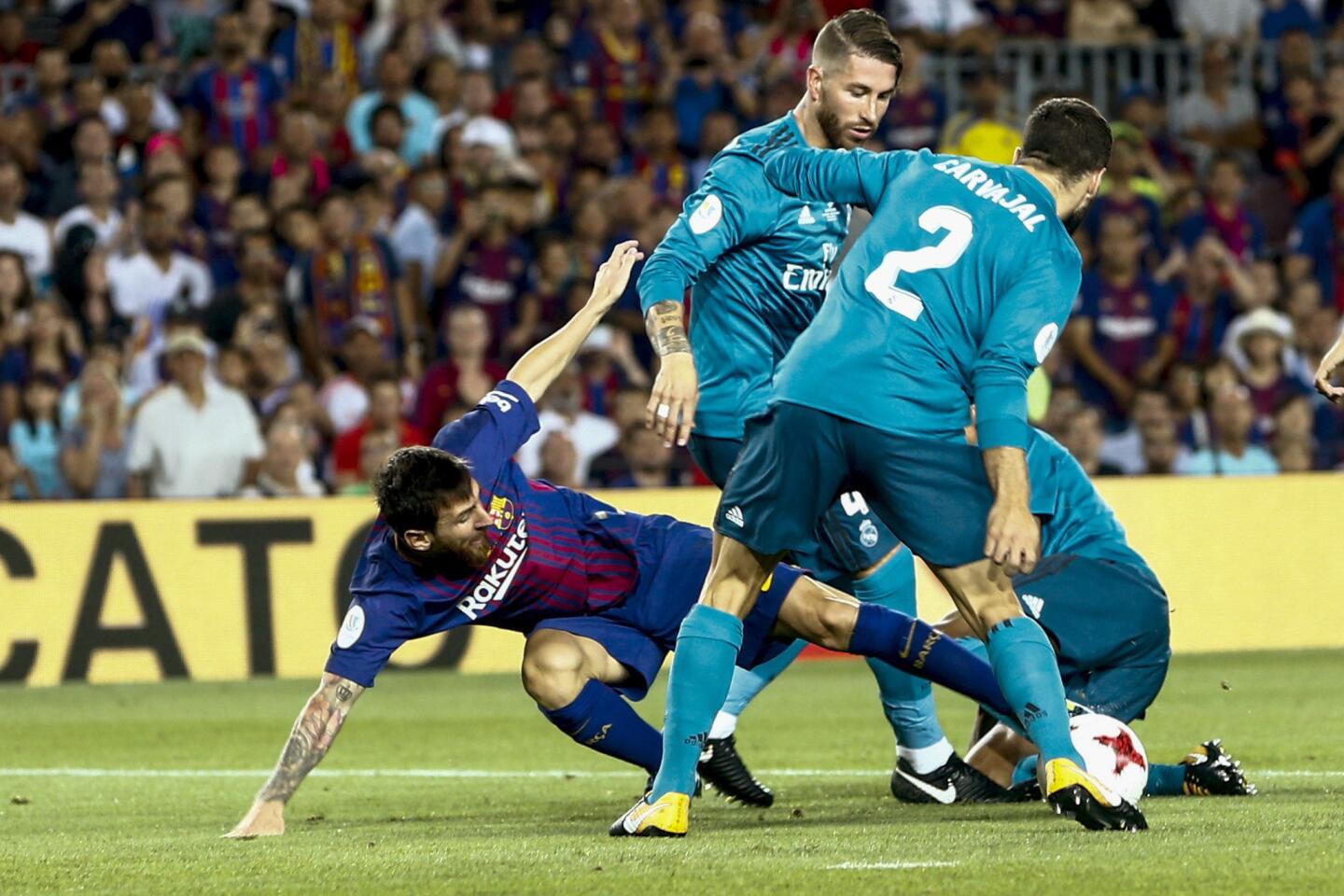 El delantero argentino del FC Barcelona Leo Messi (i) lucha el balón con Sergio Ramos (c) y Carvajal, del Real Madrid. EFE
