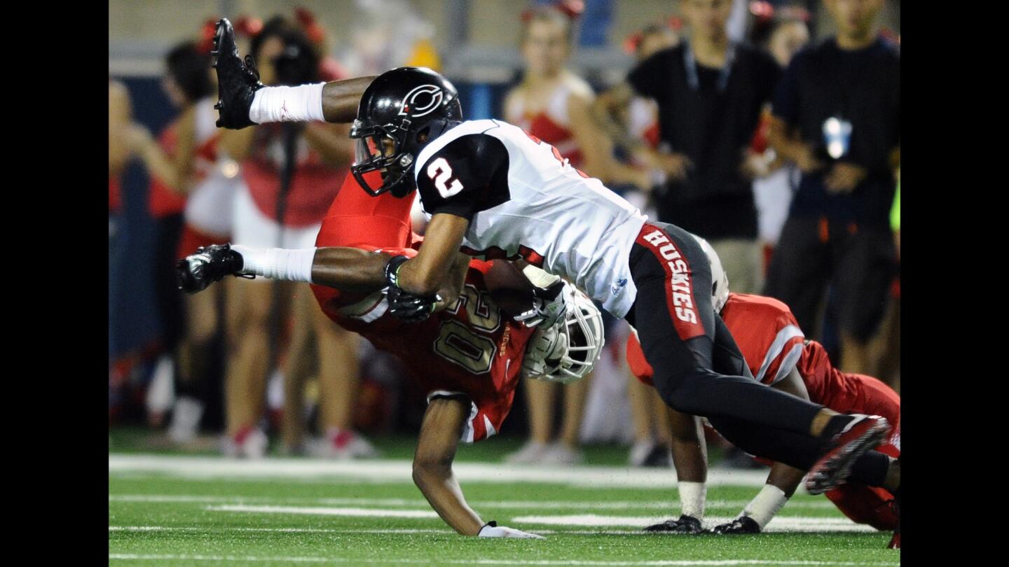 Corona Centennial's Kentrell Love upends Orange Lutheran's Malone Mataele in the third quarter of their game on Friday night at Orange Coast College in Costa Mesa.
