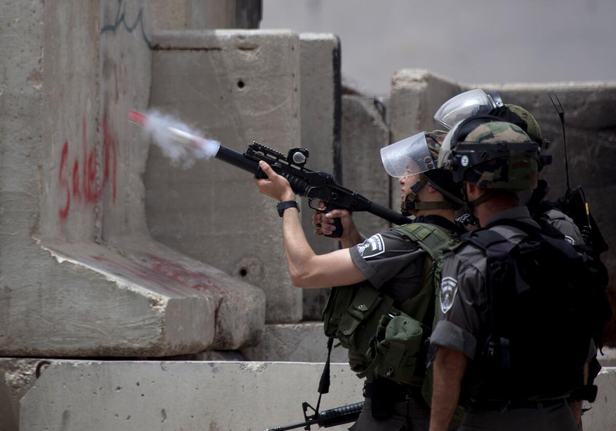 An Israeli border police officer fires a tear gas canister during clashes with Palestinians. Hamas and Fatah have been longtime rivals, but earlier this week formed a unity government, signaling an end to a seven-year split.