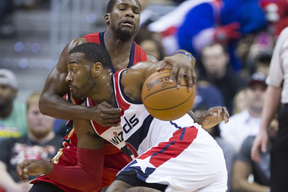 Pelicans guard Toney Douglas defends Wizards guard John Wall during the first half.