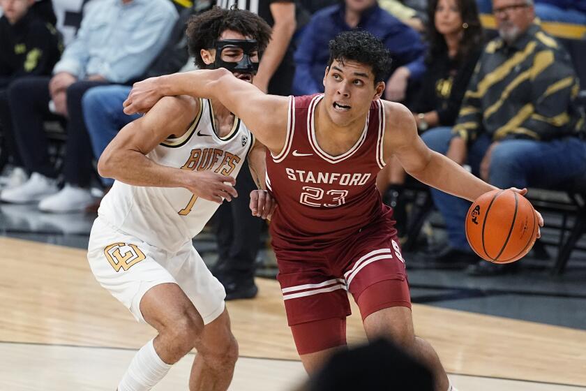Stanford forward Brandon Angel, right, drives past Colorado guard J'Vonne Hadley in the first half of an NCAA college basketball game Sunday, March 3, 2024, in Boulder, Colo. (AP Photo/David Zalubowski)