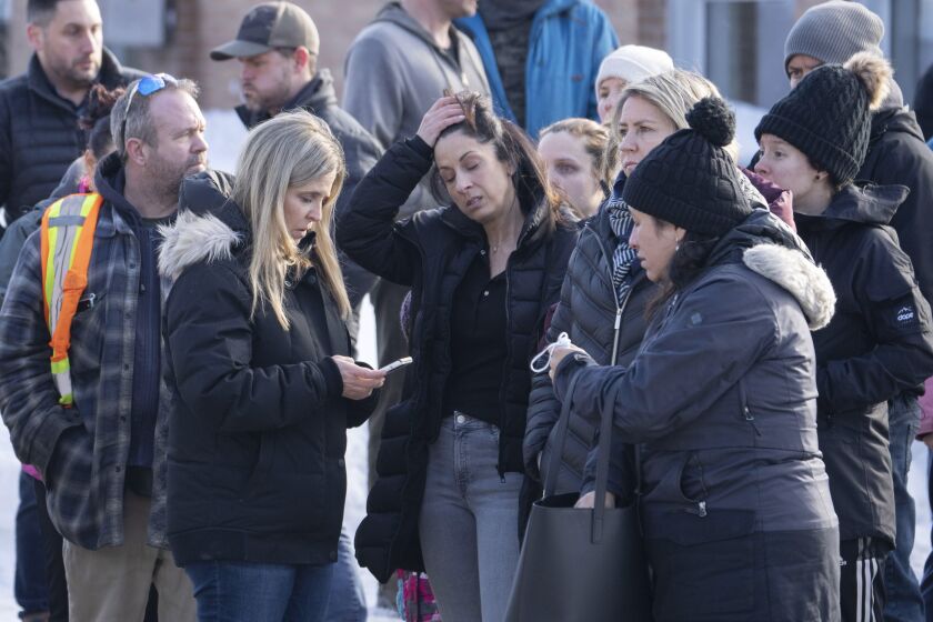 Parents wait for news after a bus crashed into a daycare centre in Laval, Quebec, on Wednesday, Feb. 8, 2023. (Ryan Remiorz/The Canadian Press via AP)