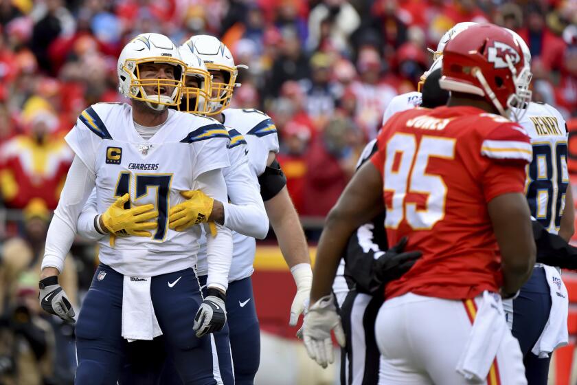 Los Angeles Chargers quarterback Philip Rivers (17) is held back by a teammate as he yells at Kansas City Chiefs defensive tackle Chris Jones (95) during the first half of an NFL football game in Kansas City, Mo., Sunday, Dec. 29, 2019. (AP Photo/Ed Zurga)