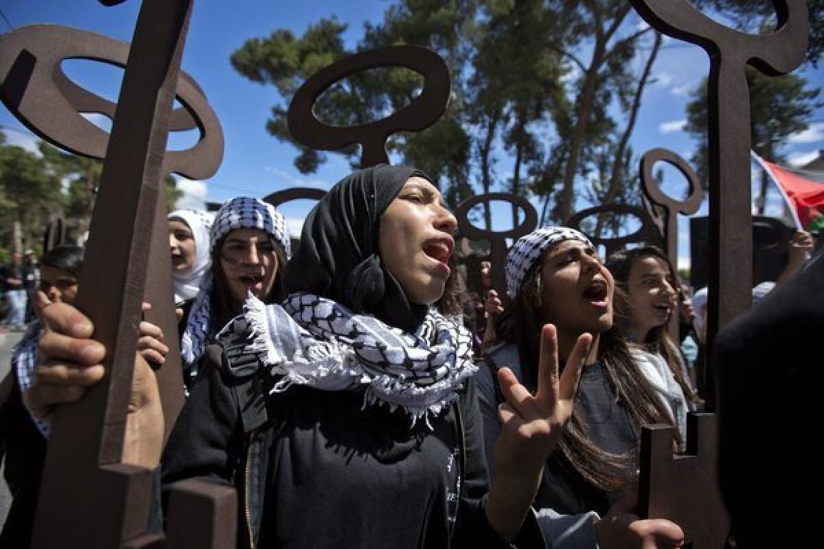 Palestinian teenagers hold up large wooden replicas of keys, symbolizing dispossessed Palestinian homes, as Palestinians mark Nakba Day in the West Bank city of Ramallah.