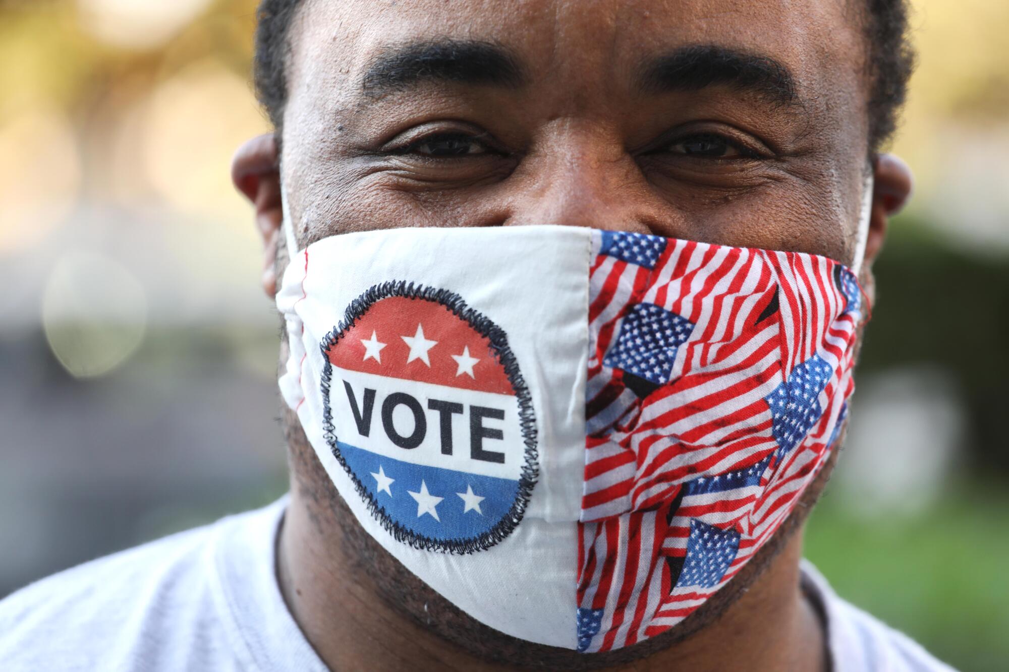 Andre Tackwood smiles under his mask after voting Oct. 15 at the Los Angeles County registrar-recorder's office in Norwalk.