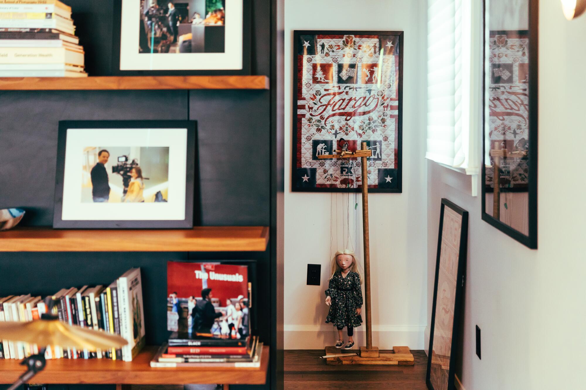 The bookshelf and wall of an office lined with books, photographs and a 'Fargo' poster.