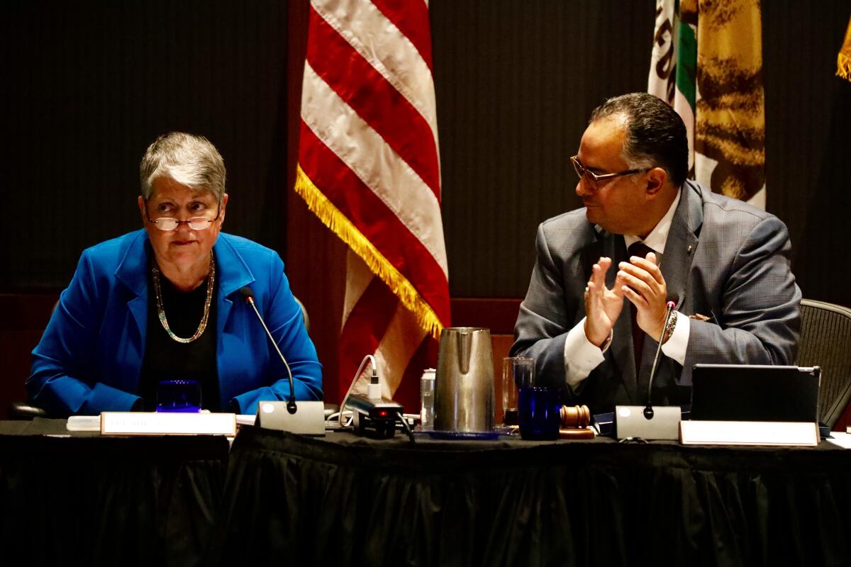 University of California President Janet Napolitano, left, 20th president of the University of California, announces she is stepping down as chairman of the board John Perez, right, leads audience in applause, September 18, 2019.