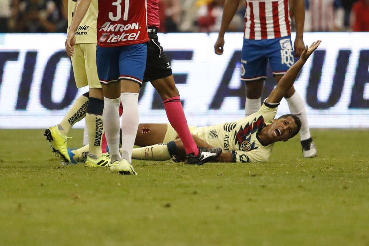 Club America's Giovani Dos Santos grimaces in pain after a tackle by Guadalajara's Antonio Briseno during a Mexican soccer league match Sept. 28 in Mexico City. America won the match 4-1.