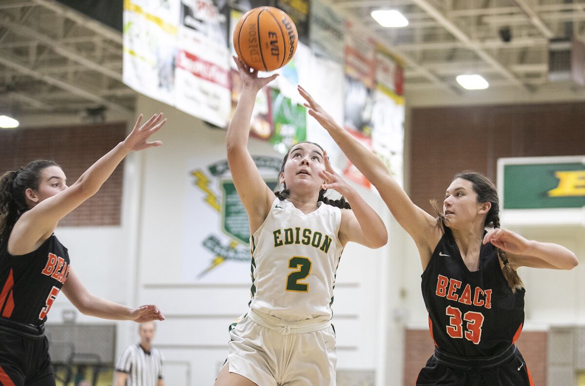 Edison's Taylor Backman goes up for a shot against Huntington Beach's Lauryn O'Neill, left, and another defender.
