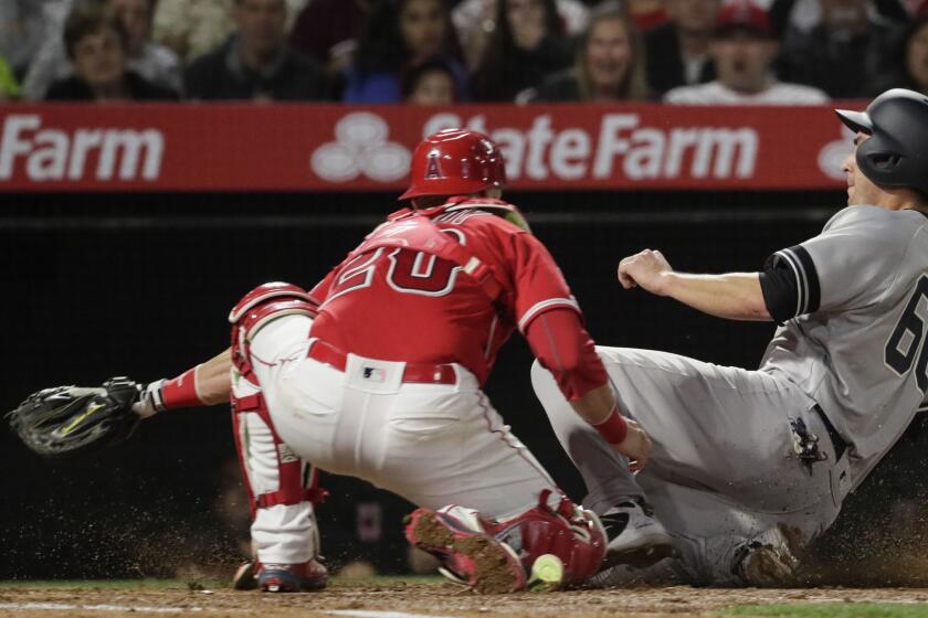 ANAHEIM, CA, MONDAY, APRIL 22, 2019 - Yankees catcher Kyle Higashioka slides safely into home as Angels catcher cant hang on to the ball on a third inning sacrifice fly by first baseman Luke Voit at Angel Stadium. (Robert Gauthier/Los Angeles Times)