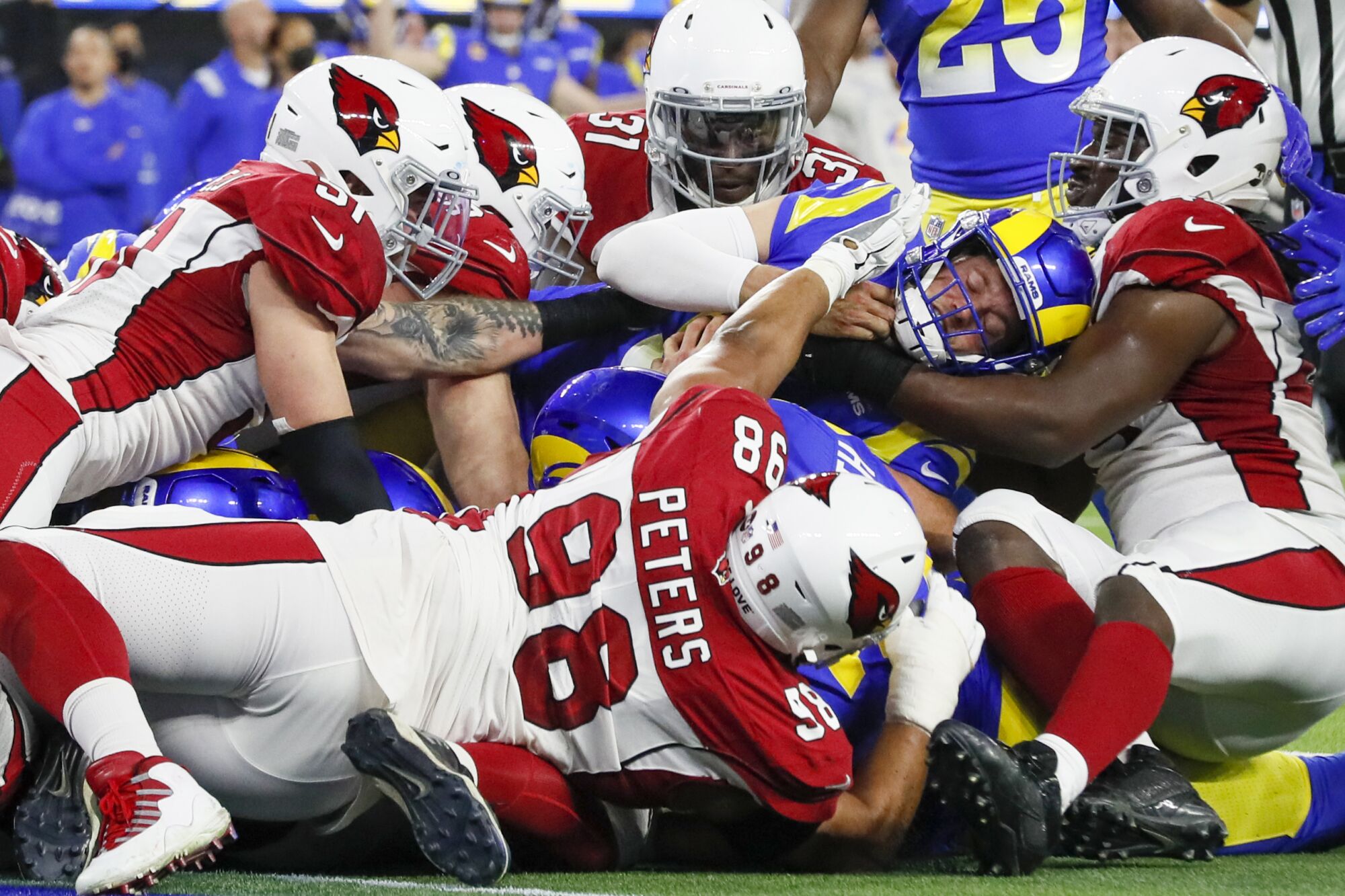 Cardinals defenders prevent Rams quarterback Matthew Stafford from scoring a touchdown.