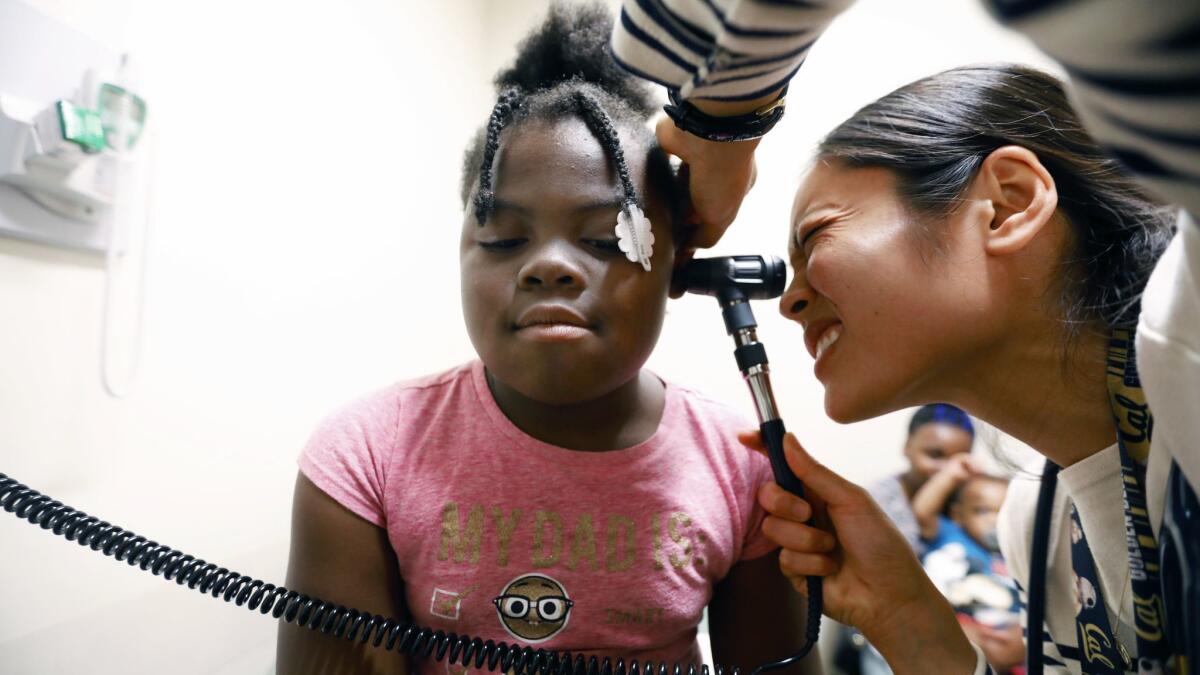 Cianna Allen, 8, is examined by Dr. Patricia Campbell at St. John's Wellness and Family Center in Los Angeles. Cianna's mother says they have lived in their car, stayed at the Union Rescue Mission and now are staying with her mother.