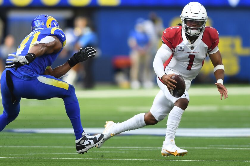 Inglewood, CA. October 3, 2021: Cardinals quarterback Kyler Murray scrambles for a first down against Rams linebacker Kenny Young in the second quarter at SoFi Stadium Sunday. (Wally Skalij/Los Angeles Times)
