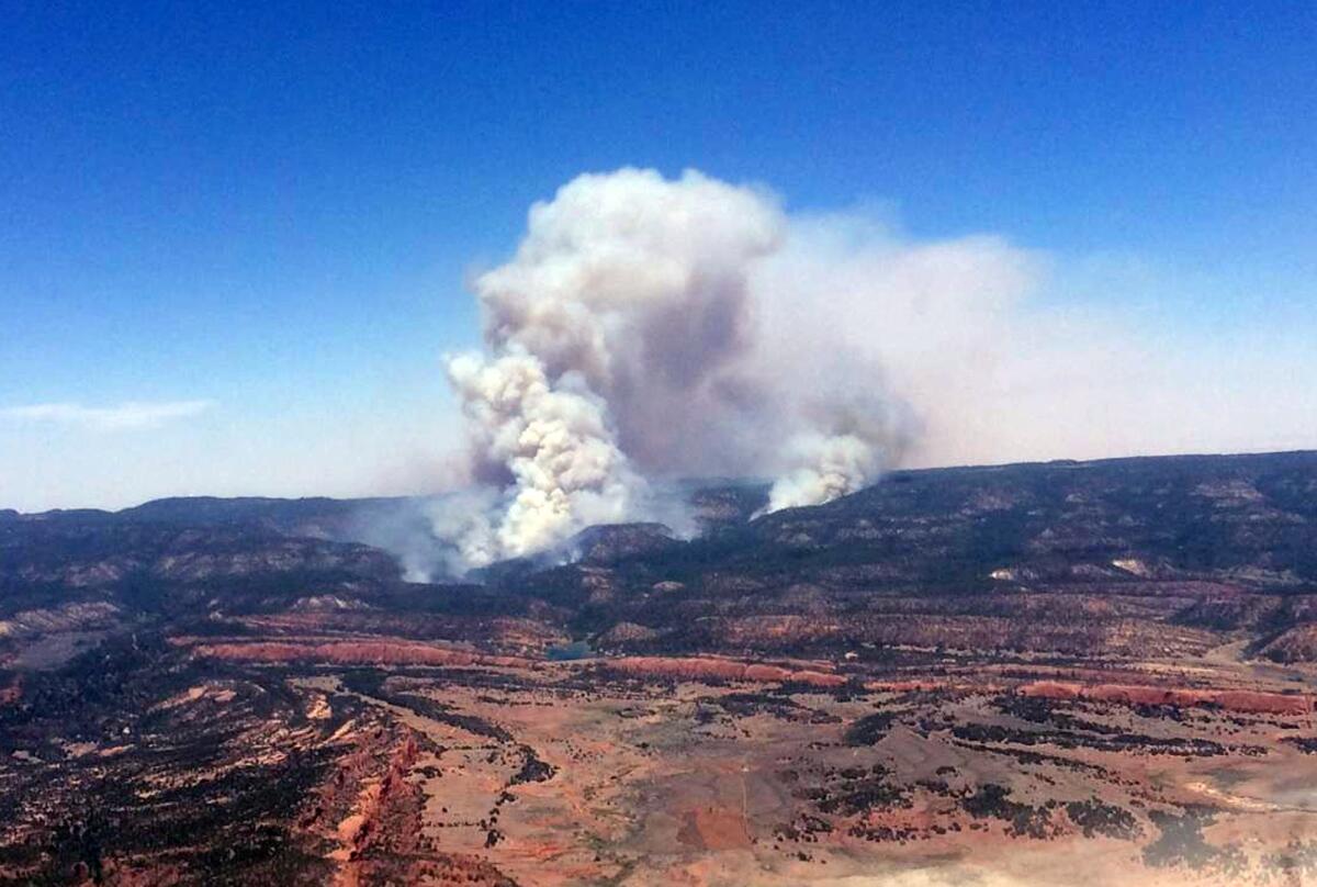A plume of smoke rises Sunday in the Chuska Mountains near Naschitti, N.M. The fire has since spread to more than 12,000 acres.