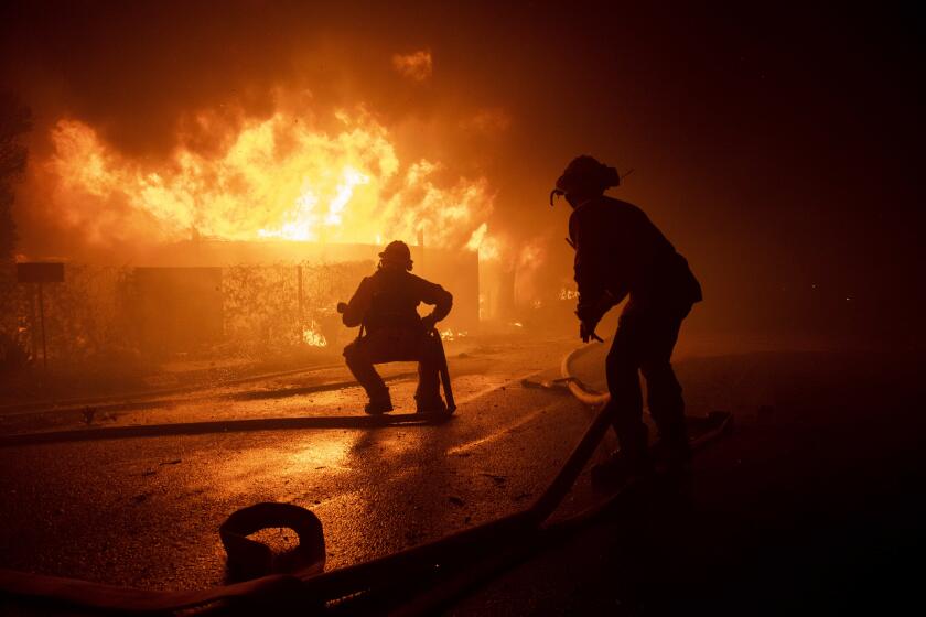 Firefighters try to save a home from a wildfire on Tigertail Road, Monday, Oct. 28, 2019, in Los Angeles, Calif. (AP Photo/ Christian Monterrosa)