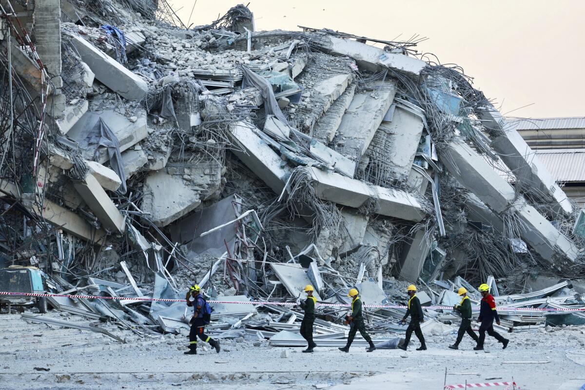 Rescuers work at the site of a high-rise building under construction that collapsed after a 7.7 magnitude earthquake.