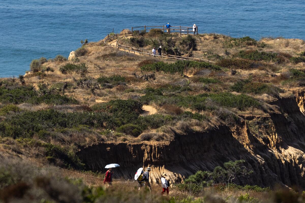 People walk along the Beach Trail at Torrey Pines State Natural Reserve on Thursday.