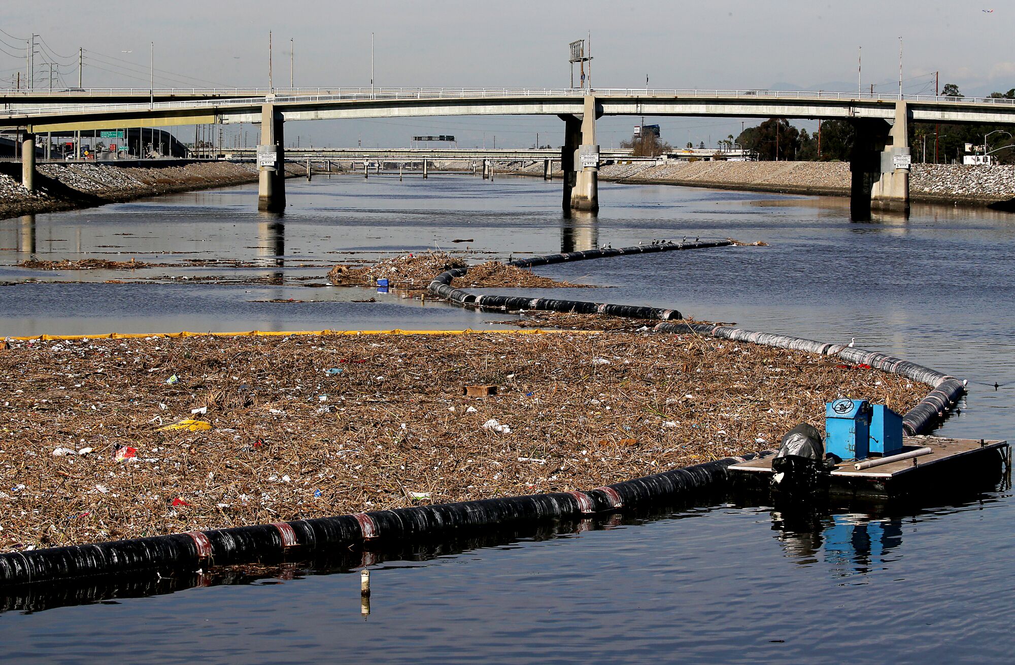 Garbage and debris is collected behind a boom at the mouth of the Los Angeles River in Long Beach on Wednesday.