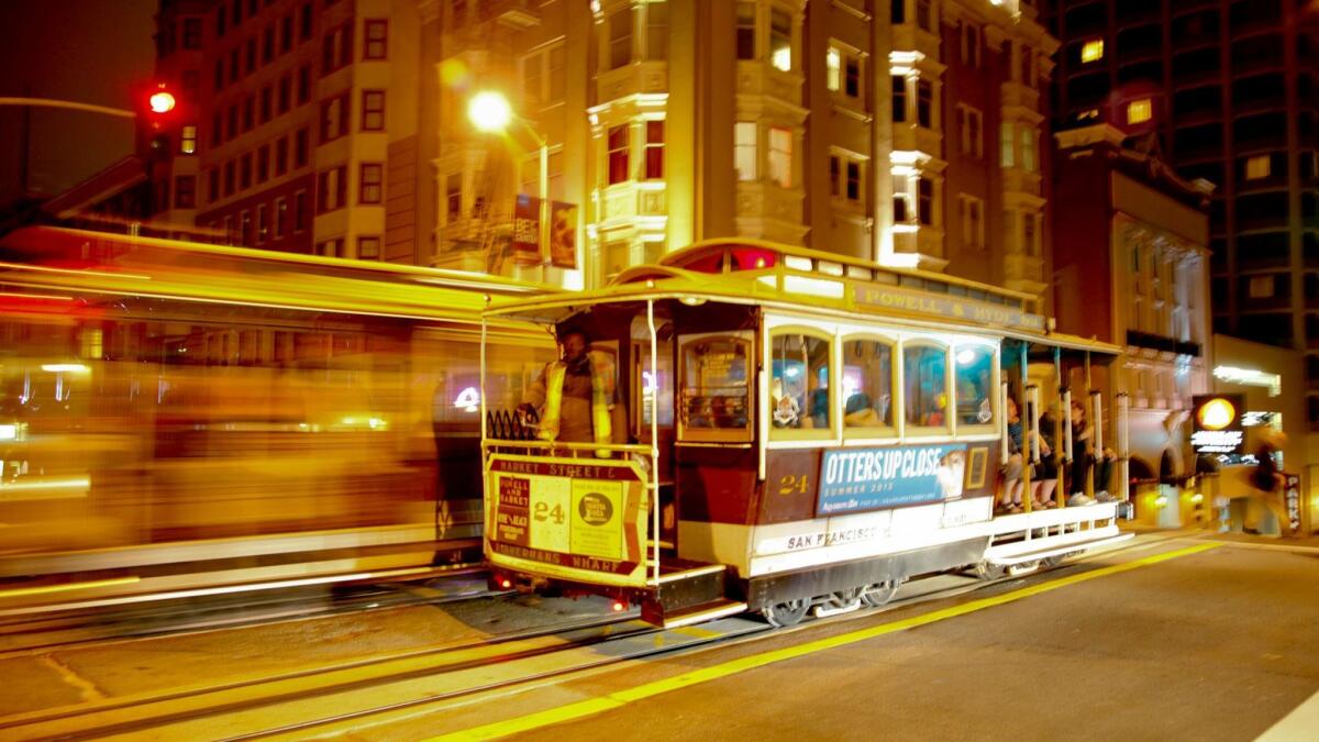 Two cable cars pass in the night on Powell Street in San Francisco.