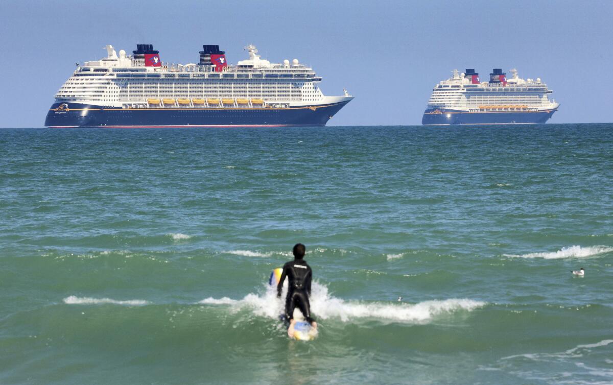 Un surfista ve en el horizonte a los cruceros "Fantasy" (i), izquierda, y "Dream" de la Disney Cruise Line