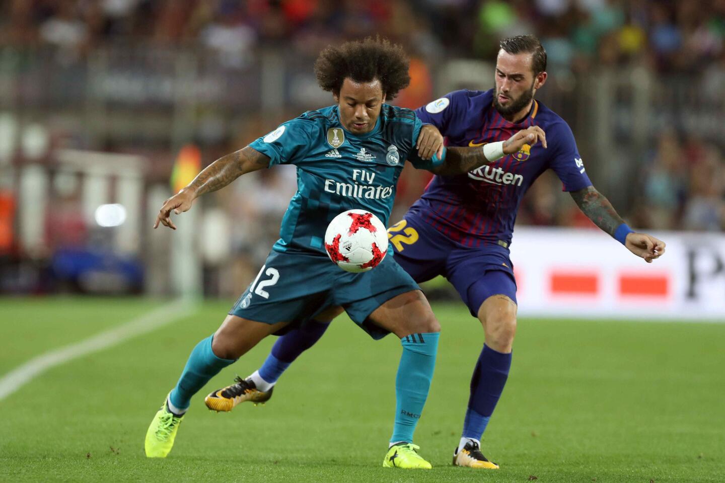 El defensa brasileño del Real Madrid Marcelo Vieira (i) controla el balón presionado por Aleix Vidal, del FC Barcelona. EFE