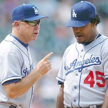 Los Angeles Dodgers pitching coach Jim Colborn, left, makes a point to starting pitcher Odalis Perez during a conference after Perez gave up hits to the first two Colorado Rockies batters.