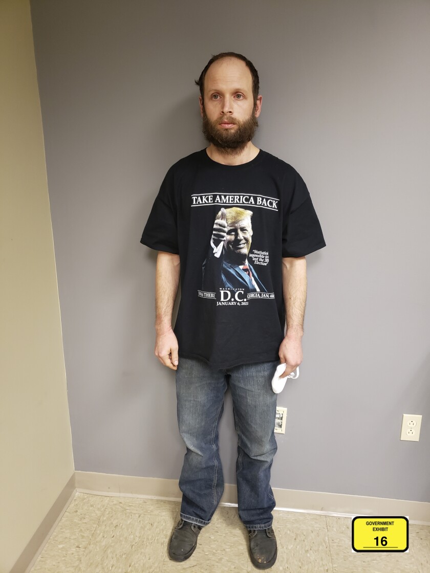 This undated photo provided by the United States Attorney’s Office, Northern District of Texas shows Garret Miller after he was arrested in Dallas. Miller didn't speak to the law enforcement officers who arrested him on charges he stormed the U.S. Capitol in January, but the T-shirt he was wearing at his Dallas home that day sent a clear and possibly incriminating message. Miller's shirt had a photograph of former President Donald Trump, and it said “Take America Back” and “I Was There, Washington D.C., January 6, 2021,” federal prosecutors noted in a court filing Monday, March 29, 2021. (United States Attorney’s Office, Northern District of Texas via AP)