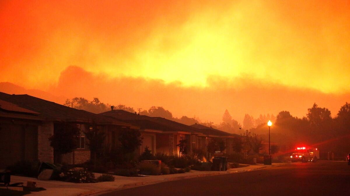 Fire trucks monitor a fire that threatens the Oakmont community in Santa Rosa.