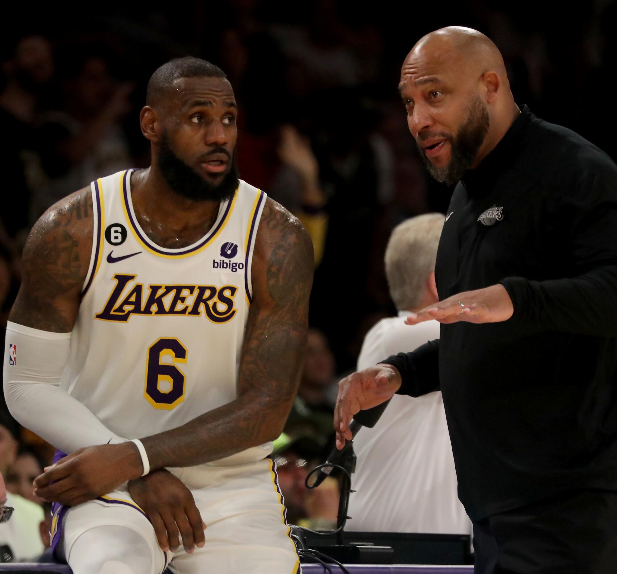Lakers coach Darvin Ham talks to LeBron James along the sideline during the fourth quarter Sunday.