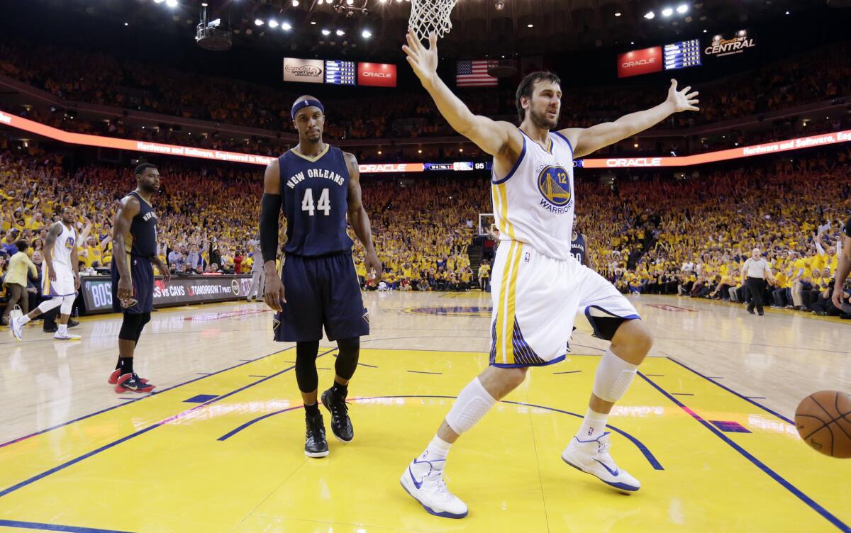 Warriors center Andrew Bogut celebrates after a dunk late in the fourth quarter while Pelicans Dante Cunningham looks on.