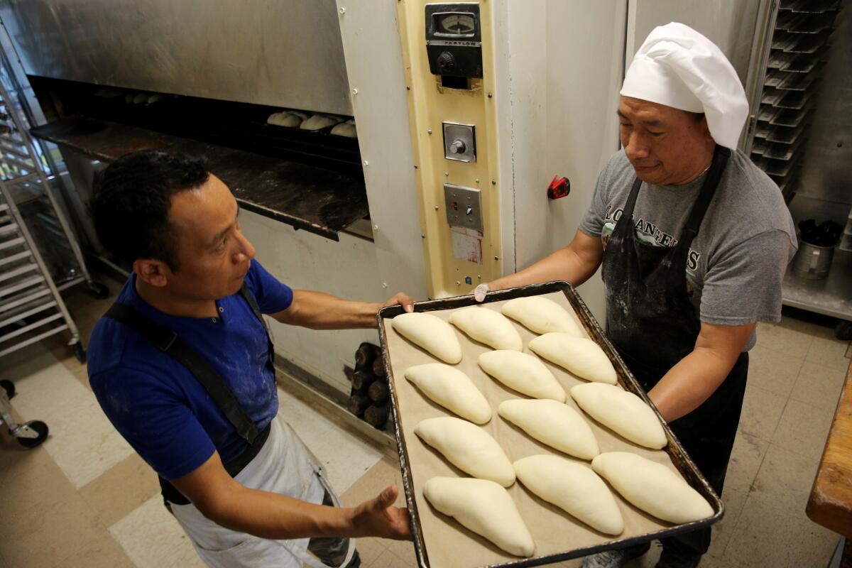 Ricardo Chanax, de 35 años (izquierda), y su hermano José Chanax, de 45 años, hornean pan de 6 am a 4 pm.