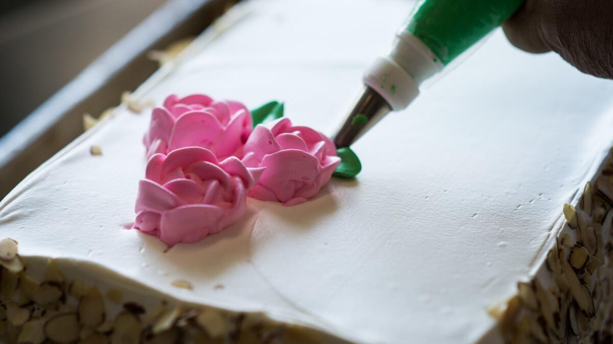 Youlen Chan decorates cakes at Phoenix Bakery.