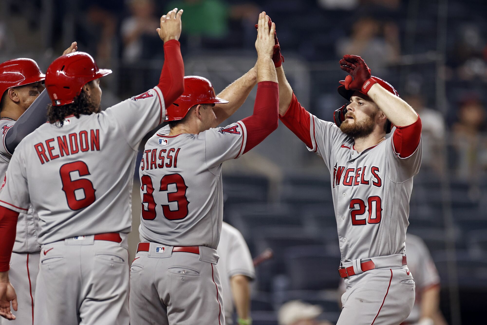 Jared Walsh (20) celebrates with Angels teammates after hitting a grand slam in the ninth inning.
