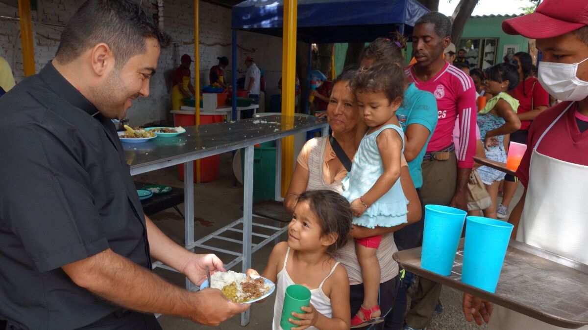 Father Leonardo Mendoza hands out meals to Venezuelan migrants at the Divine Providence Cafeteria run by the local diocese in Villa de Rosario, a Cucuta suburb. "Children come up to me and say "Father, I'm hungry,'" he said. "It's heartbreaking."