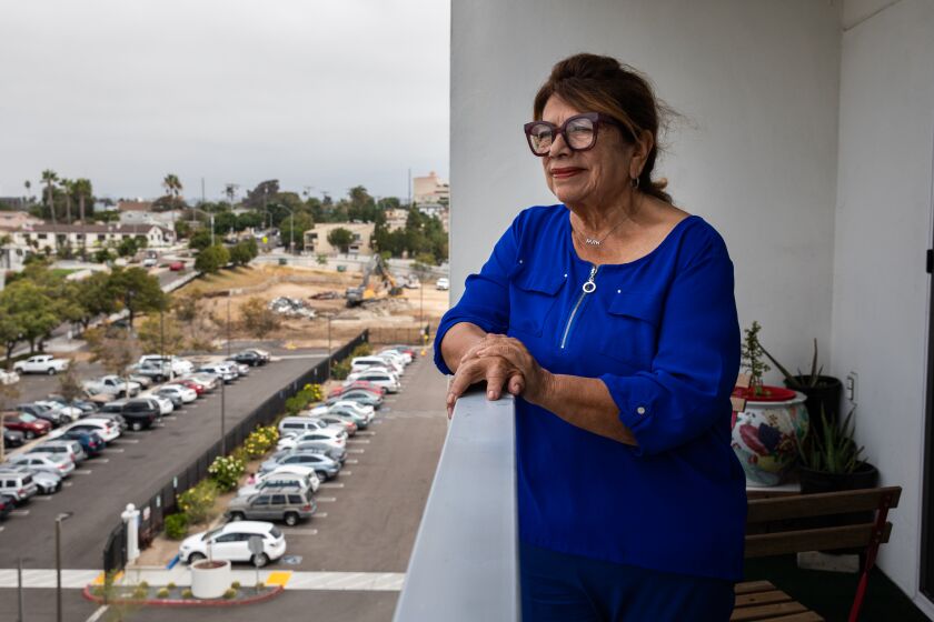 National City, CA - August 24: Gloria Salas looks out the balcony of her apartment at Morgan Kimball Towers, an apartment building for seniors in National City, CA on Wednesday, Aug. 24, 2022. Salas used to go to the senior center twice a week before it was shut down during the pandemic. Since then, the city has begun construction of a new center, but it could be at least another two years before it opens up. Las Palmas Pool, where Salas would go swimming at least three times a week, is also under construction. Salas worries that a lack of activities and socialization for seniors is causing them to feel neglected and bored. (Adriana Heldiz / The San Diego Union-Tribune)