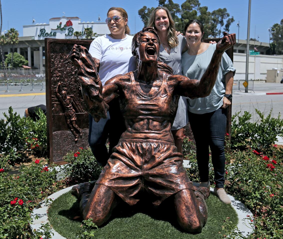 From left, former goalie Saskia Webber, honoree Brandi Chastain, and player Lorrie Fair stand with just-unveiled statue of Chastain, at the Rose Bowl in Pasadena on Wednesday, July 10, 2019. Chastain's sculpture was made by artist Brian Hanlon from an image taken when the 1999 USA women's soccer team won the world cup.
